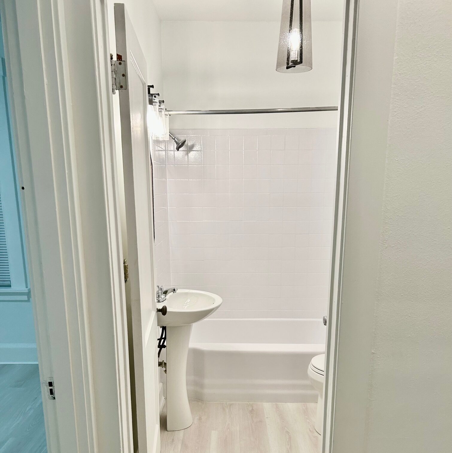 Bathroom renovated as part of ready-to-rent whole home refresh featuring updated flooring, fresh interior paint, modern fixtures and professionally reglazed tub.